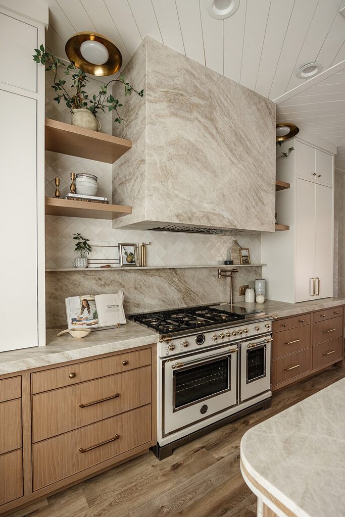 Wide-angle view of custom kitchen design with open shelving and brass accents in Alpine studio build