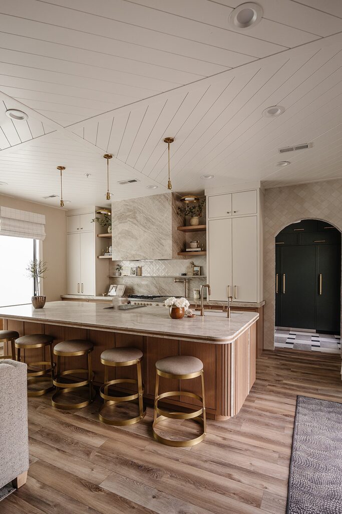 Wide-angle view of custom kitchen design with open shelving and brass accents in Alpine studio build