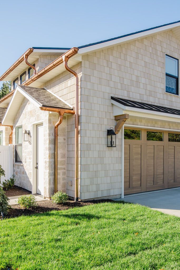Front elevation of a Utah custom home featuring wood accents, clean lines, and detailed landscaping