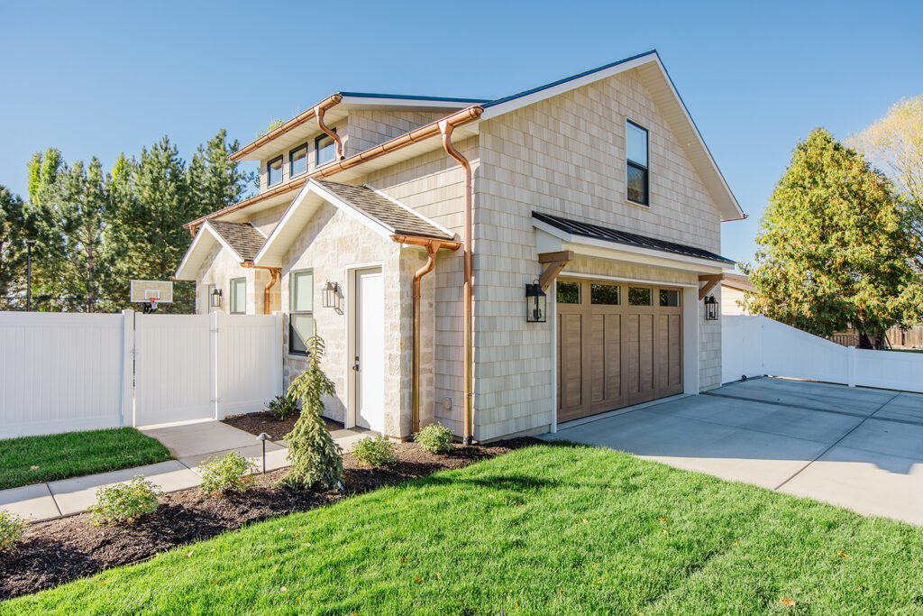 Front elevation of a Utah custom home featuring wood accents, clean lines, and detailed landscaping