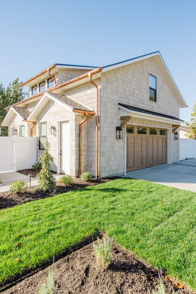 Front elevation of a Utah custom home featuring wood accents, clean lines, and detailed landscaping