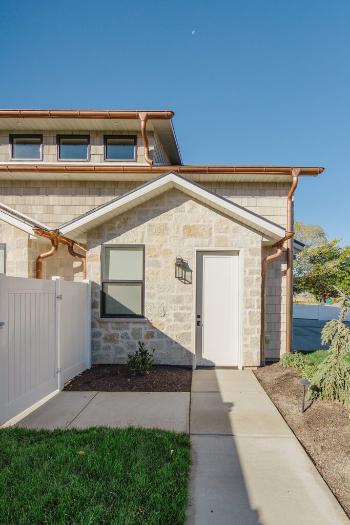 Exterior view of the Campbell Project, a custom home built in Utah with warm stone and timeless architecture