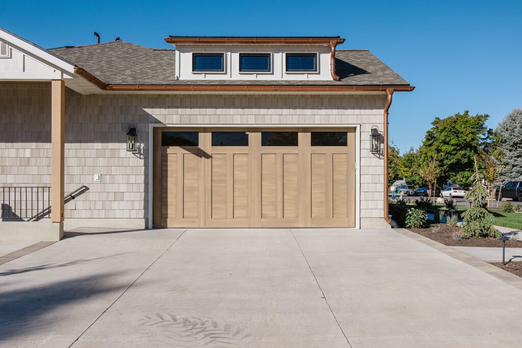 Driveway and entryway of the Campbell custom home built in Utah showcasing natural textures and modern design.