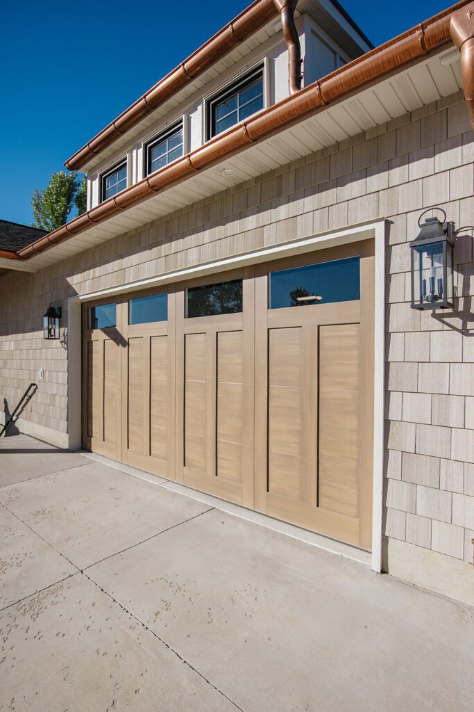 Driveway and entryway of the Campbell custom home built in Utah showcasing natural textures and modern design.