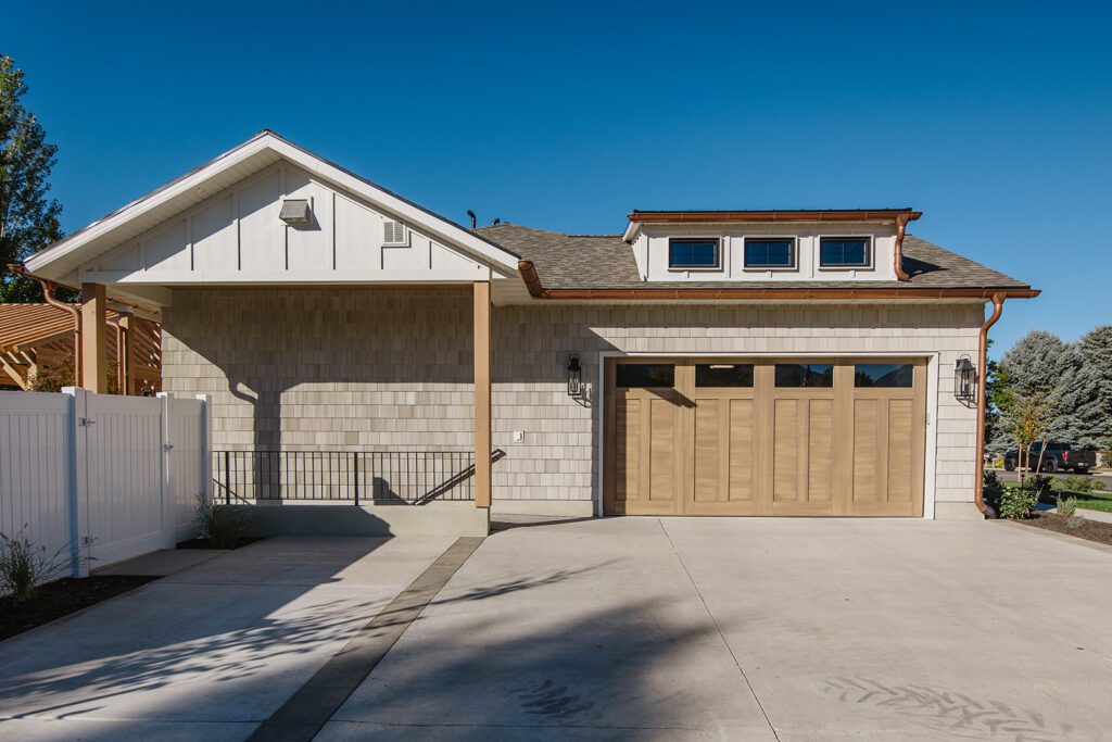 Driveway and entryway of the Campbell custom home built in Utah showcasing natural textures and modern design.