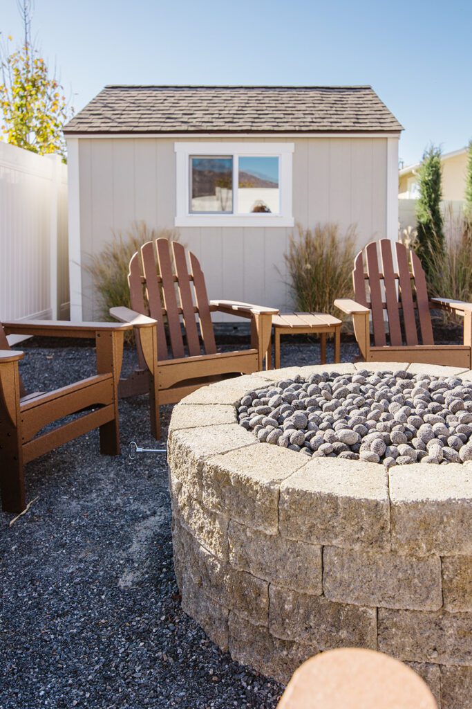 Back exterior of a Utah custom home with large windows, patio space, and beautiful yard design
