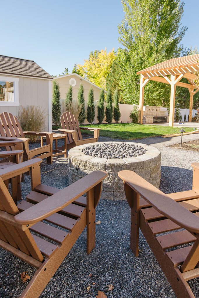 Back exterior of a Utah custom home with large windows, patio space, and beautiful yard design