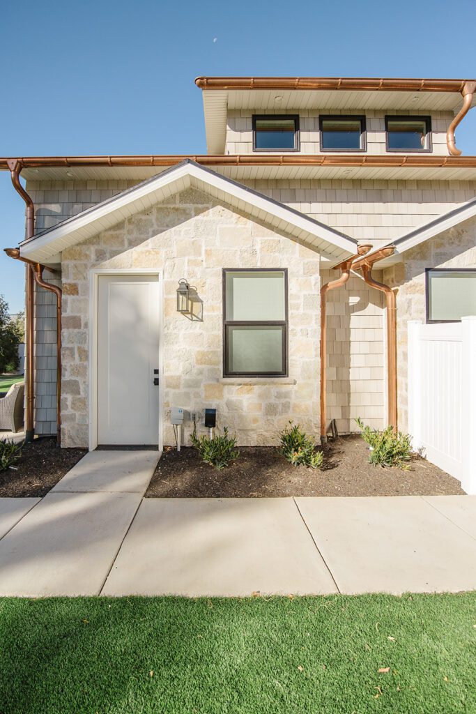 Driveway and entryway of the Campbell custom home built in Utah showcasing natural textures and modern design.