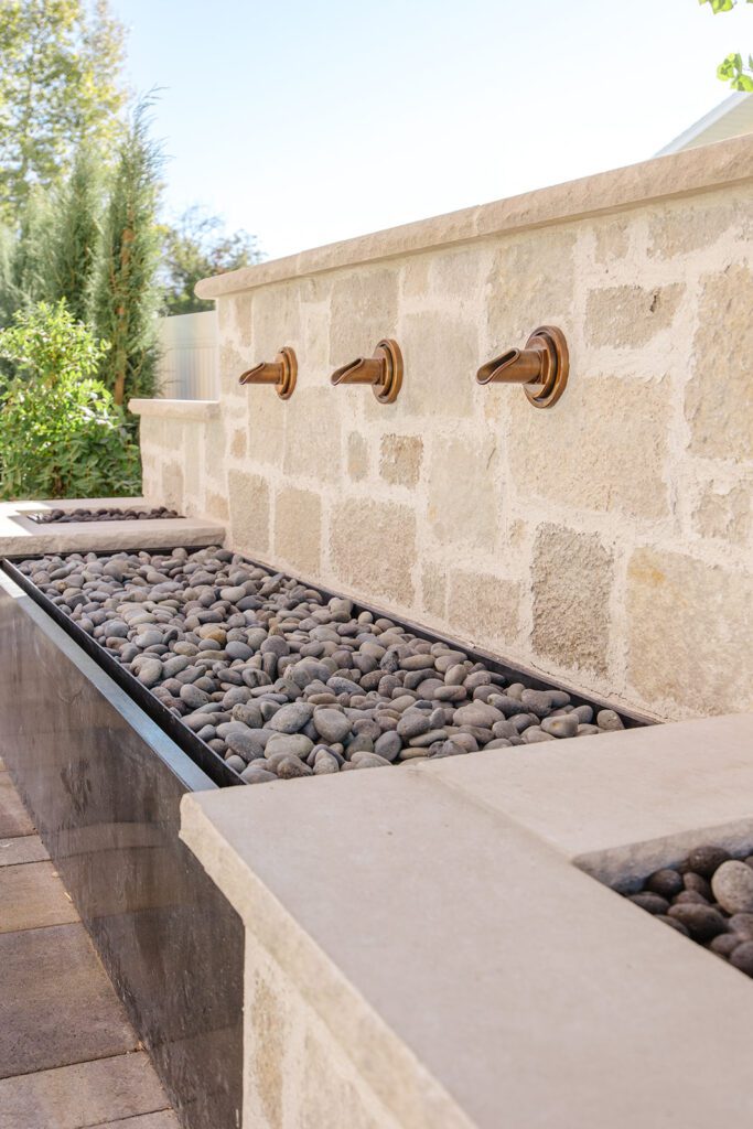 Back exterior of a Utah custom home with large windows, patio space, and beautiful yard design