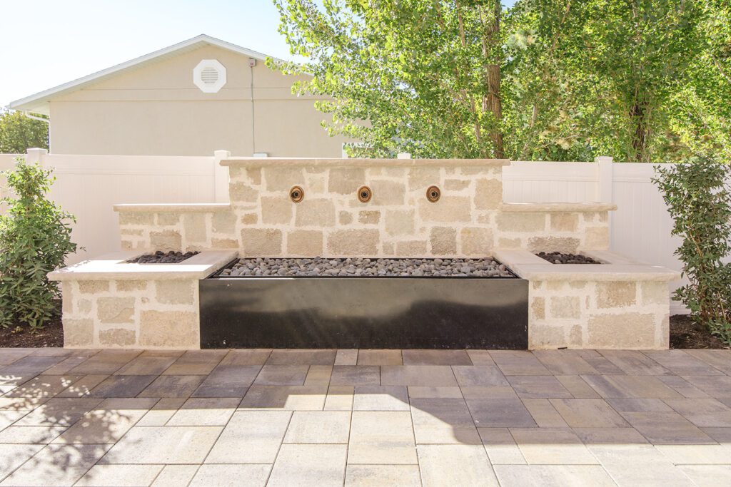Back exterior of a Utah custom home with large windows, patio space, and beautiful yard design