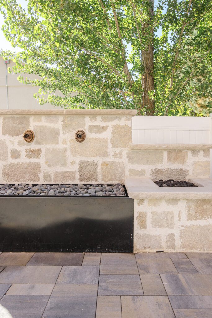 Back exterior of a Utah custom home with large windows, patio space, and beautiful yard design