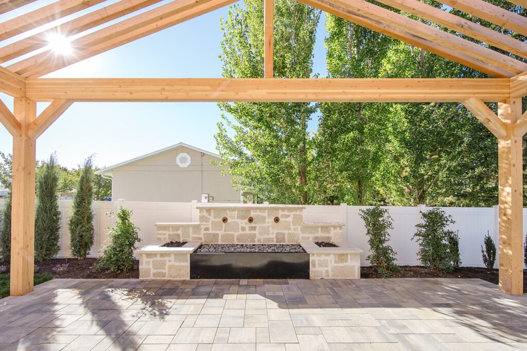 Back exterior of a Utah custom home with large windows, patio space, and beautiful yard design