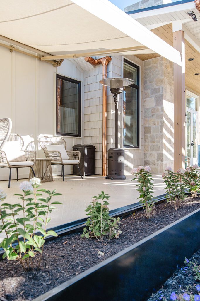 Back exterior of a Utah custom home with large windows, patio space, and beautiful yard design