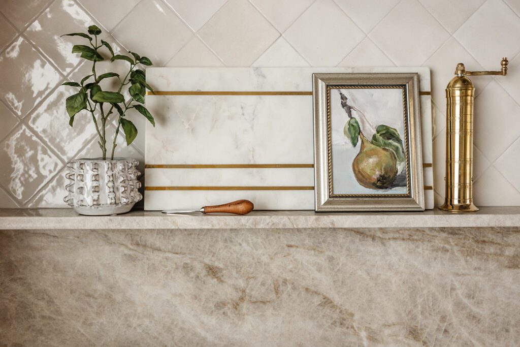 Close-up of textured tile backsplash and brass hardware in Alpine studio kitchen project.